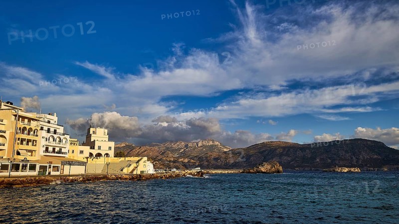 Morning light, coastal town with buildings by the sea and mountains in the background, Pigadia, town and harbour, Pigadia Bay, main town, Karpathos, Dodecanese, Greek Islands, Greece, Europe
