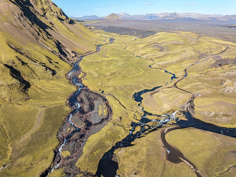 Road F232 Öldufellsleid, ford at waterfall of river bláfjallakvísl, along northern slopes of moss-covered Mt. Öldufell, Mt. Maelifell in the back, black lava sand, aerial view, Iceland, Europe