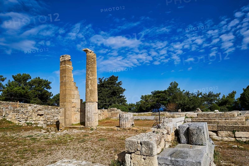 Two ancient columns amidst ruins and stone walls under a clear blue sky, Temple of Apollo, Kamiros, Archaeological site, Ancient city, Foundation of Doric Greeks, Rhodes, Dodecanese, Greek Islands, Greece, Europe