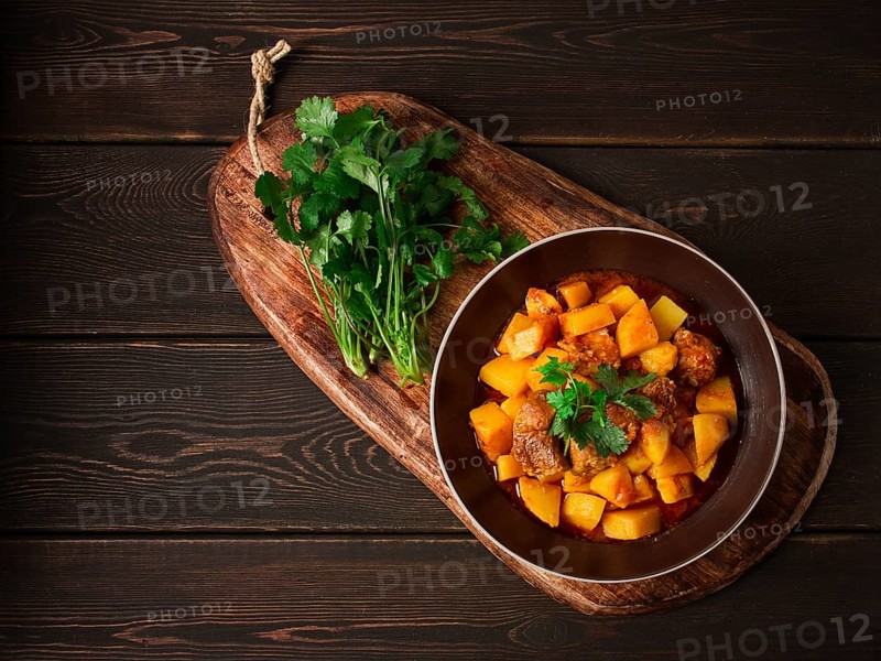 Potatoes stewed with meat, in tomato sauce, with spices and herbs, no people