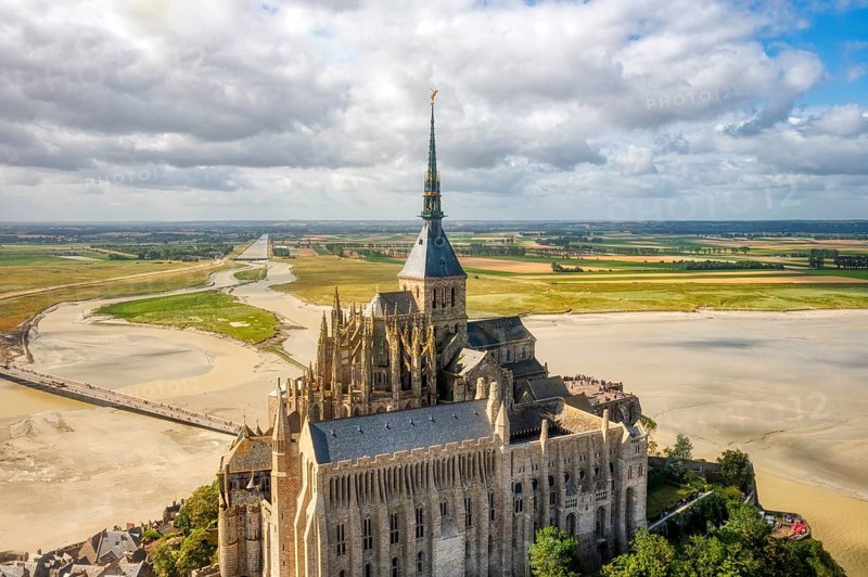 Aerial view of the imposing abbey in an extensive sand and water landscape, Le Mont-Saint-Michel