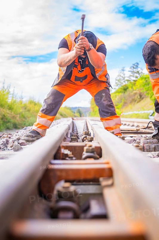Two construction workers working on the rails, looking along the tracks in a rural setting, rail welding, track construction Hermann Hessebahn, Calw, Black Forest, Germany, Europe