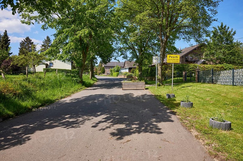 Entrance to the village with road and village sign for the district of Pesch, Nettersheim, Eifel, Euskirchen district, North Rhine-Westphalia, Germany, Europe
