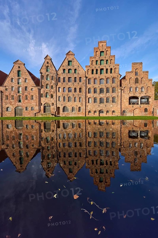 Historic salt warehouses, brick buildings reflected on the water surface of the Trave, blue sky with veil clouds, Hanseatic city of Lübeck, independent city, Schleswig-Holstein, Germany, Europe