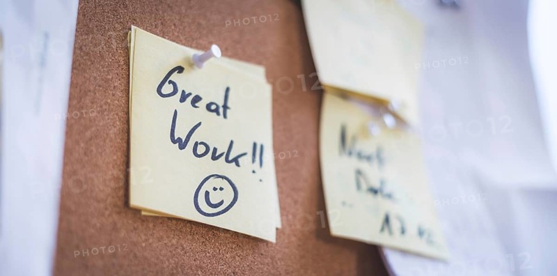 Close up of pinned note ?Great work? on cork board