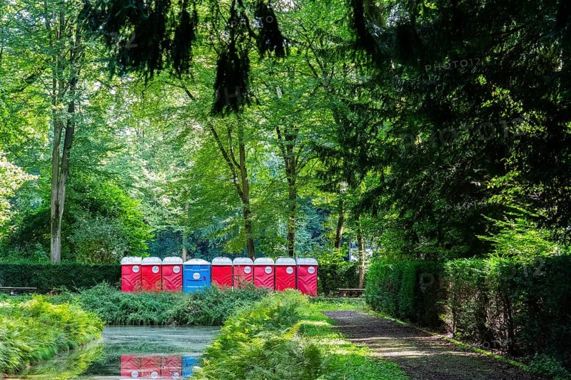 A row of red and blue toilet blocks in the park after an event, Düsseldorf, Germany, Europe