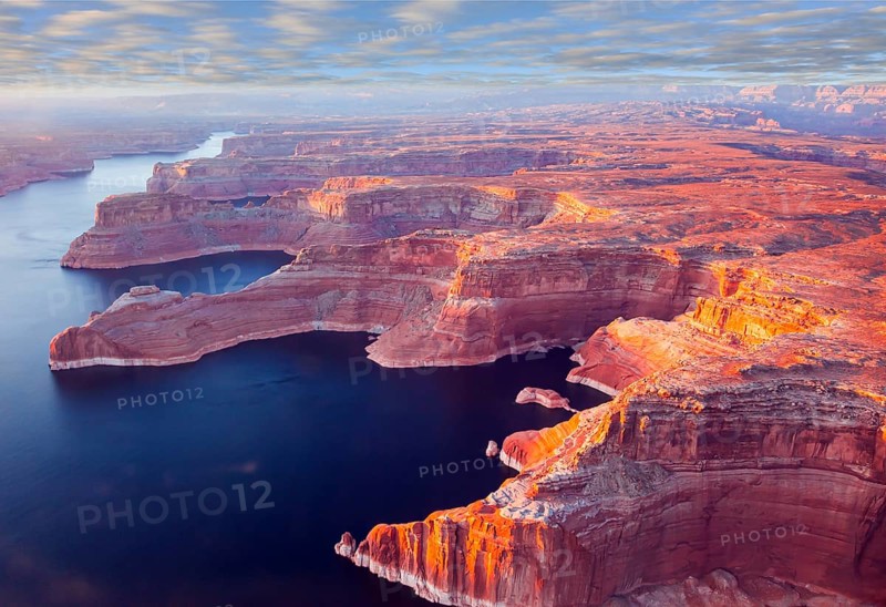 Landscape under the wing of an airplane. U.S. The coast of Lake Powell is cut by narrow canyons. Grandiose huge lake of artificial origin among the picturesque red sandstone cliffs