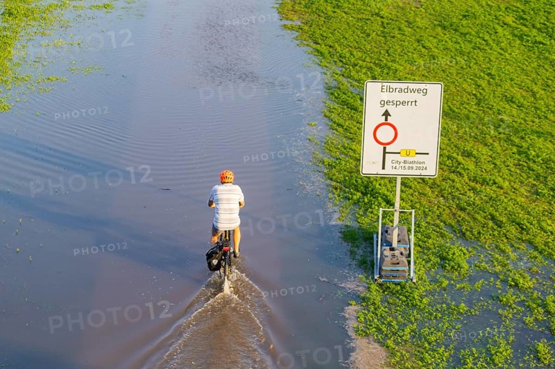 A weather-determining low-pressure system is moving from northern Italy on a so-called Vb track via Austria and the Czech Republic to Poland, bringing very humid air with it. This will also lead to flooding in the Elbe in Saxony. On 18.9.24, the level of the Elbe in Dresden is 6.06m. Cyclists on the Elbe cycle path, which is closed due to flooding, Elbe floods in Dresden, Dresden, Saxony, Germany, Europe