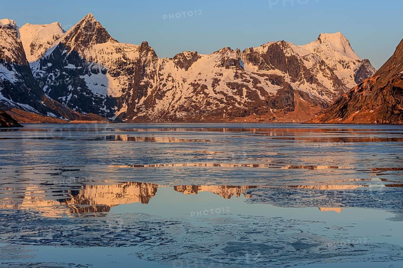 Fjord with ice floes in front of steep mountains, reflection, morning light, KjerkfjordeWinter, Reine, Moskenesoya, Lofoten, Norway, Europe