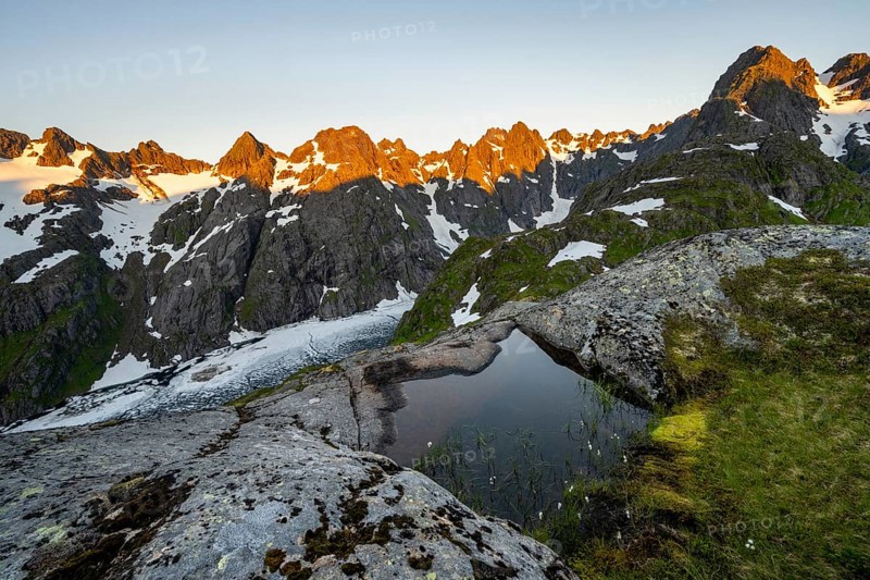 Rocky mountain peaks, small pond with cotton grass in moor landscape at Trollfjord Hytta, mountain landscape with alpenglow at sunrise, at Trollfjord, Lofoten and Vesterålen, Nordland, Norway, Europe