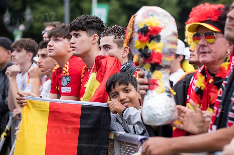 Spanish and German football fans next to each other in the front row of the fan zone at the Brandenburg Tor tor during the quarter-final match between Germany and Spain at the European Football Championship, Berlin, 05/07/2024