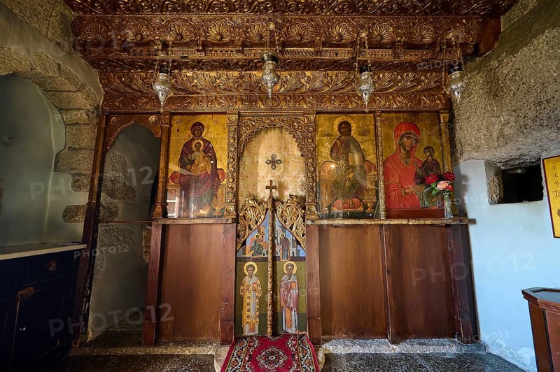 An altar in a church with religious icons, carved wood and candle lighting, Apokalipsis Monastery, Patmos, Dodecanese, Greek Islands, Greece, Europe