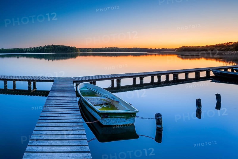 Wooden jetty with rowing boat at dusk, sunset on Lake Schaalsee, Mecklenburg-Western Pomerania, Germany, Europe