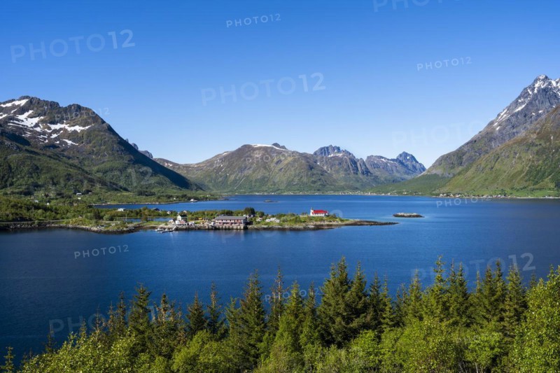 Landscape on the Lofoten Islands with sea and mountains. The Sildpollnes peninsula in the Austnesfjord with a church and a few houses. Good weather, blue sky. Early summer. Sildpollnes, Austvagoya, Lofoten, Norway, Europe