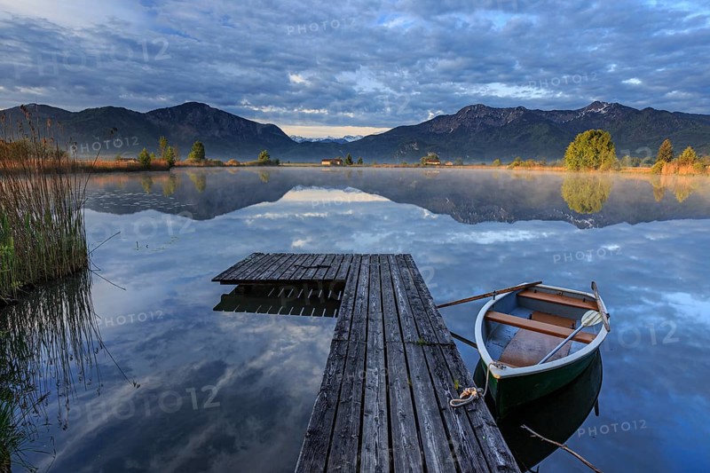 Mountains reflected in lake, jetty and boat, morning light, spring, Loisach-Lake Kochel moor, Bavaria, Germany, Europe