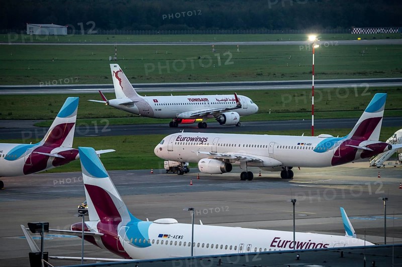 Düsseldorf Airport, Eurowings aircraft, in parking position, Tunisair on the taxiway for take-off