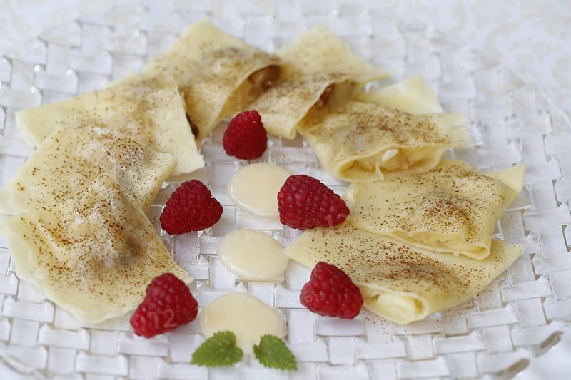 Swabian cuisine, apple ravioli, apple in pasta dough, sweet dish, dessert, vanilla sauce, cinnamon, raspberries, arranged on a plate, grandmother's kitchen, regional, home cooking, typical Swabian, classic recipe, traditional cuisine, food photography, studio, Germany, Europe