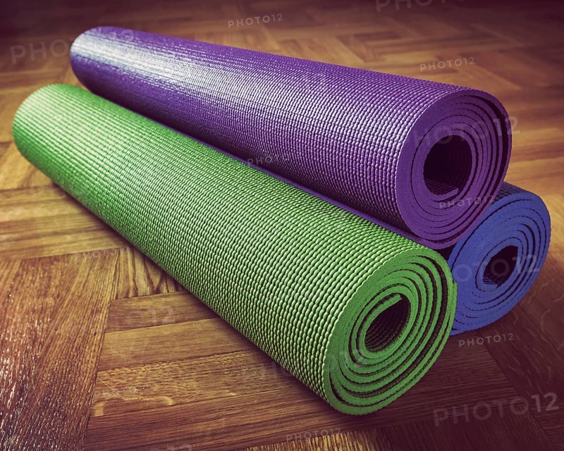 Vintage retro effect filtered hipster style image of Yoga mats on wooden floor