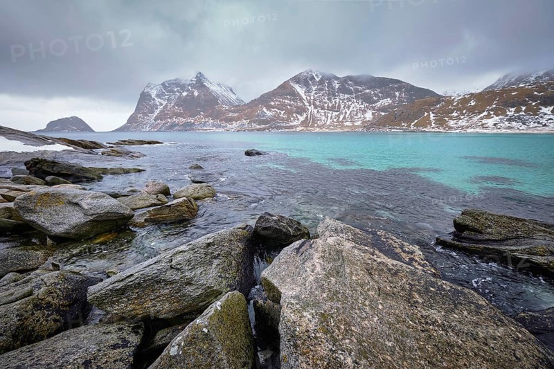 Rocky coast of fjord of Norwegian sea in winter with snow. Haukland beach, Lofoten islands, Norway, Europe