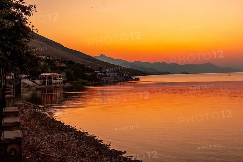 Beautiful orange summer sunset at Shkoder Lake in Shiroka Municipality. Albania
