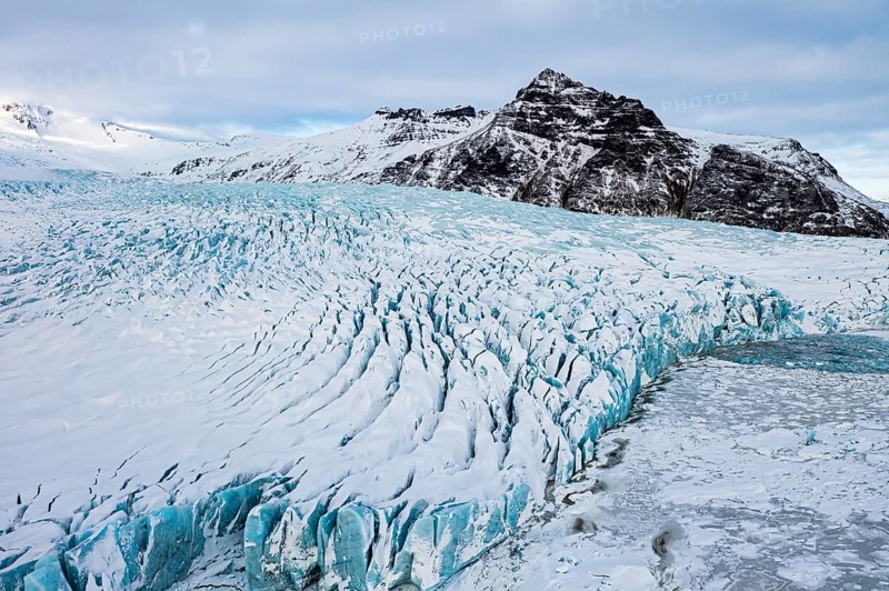 Snow-covered icebergs in the Fjallsarlon glacier lagoon, with the Öraefajökull glacier behind, drone shot, Sudurland, Iceland, Europe
