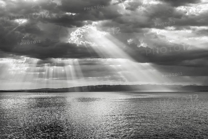 Tyndall effect over Lake Constance, sun rays break through cloudy sky and reflect on the water, Canton Thrugau, Switzerland, Europe