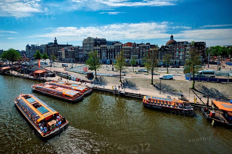 AMSTERDAM, NETHERLANDS, MAY 9, 2017: Aerial view of Amsterdam canal with tourist boats near Amsterdam Centraal