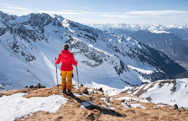 Ski tourer standing next to summit cross, summit of Mitterzeigerkogel in winter, Sellraintal, Kühtai, Tyrol, Austria, Europe