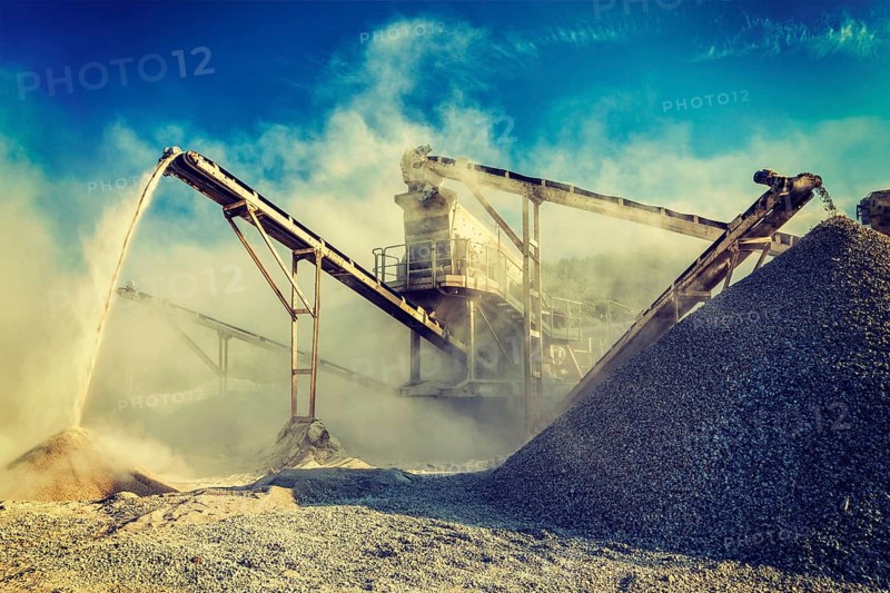 Vintage retro effect filtered hipster style image of Industrial background, crusher rock stone crushing machine at open pit mining and processing plant for crushed stone, sand and gravel