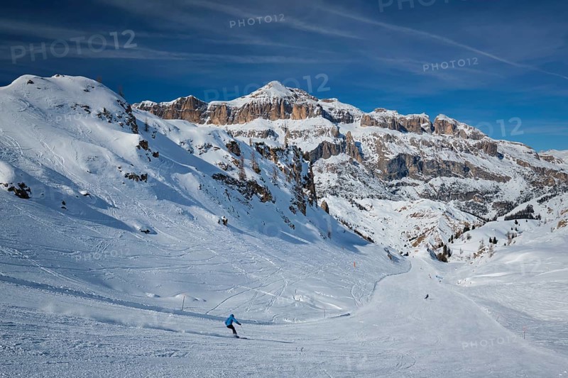 View of a ski resort piste with people skiing in Dolomites in Italy. Ski area Arabba. Arabba, Italy, Europe