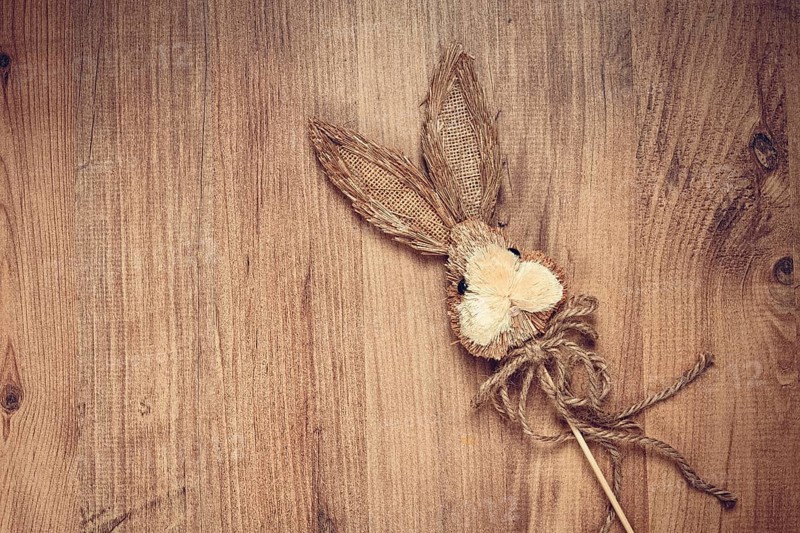 Easter bunny made of straw, on a wooden background, top view, no people