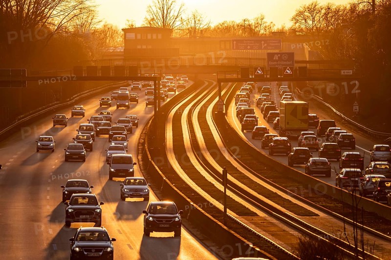 Motorway A40, dense, slow-moving traffic jam, evening traffic at the Essen-Kray junction, low sun, public transport bus lane in the middle of the motorway, North Rhine-Westphalia, Germany, Europe