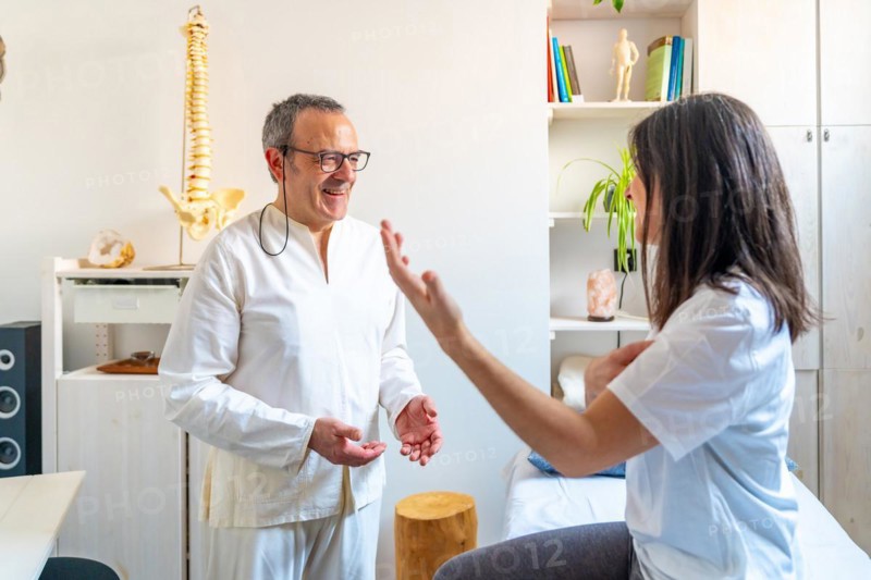 Patient talking to a expertise Qi gong masseur and she explaining where it hurts