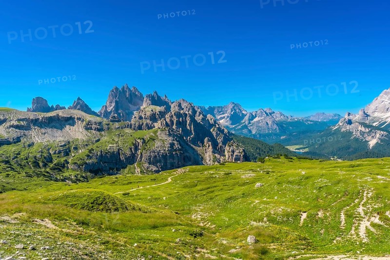 Breathtaking landscape of tre cime di lavaredo peaks towering above lush green meadows in the italian dolomites, a unesco world heritage site. Summer holidays in the Italian Dolimites. Italy
