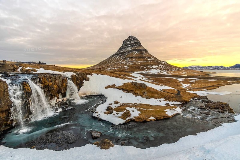 Wonderful sunrise landscapes on famous Kirkjufell mountain next to waterfall in winter Iceland