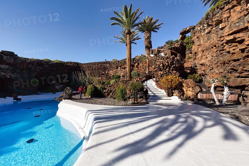 Palm trees, people walking by the swimming pool, Jameos del Agua, Lanzarote, Spain, Europe
