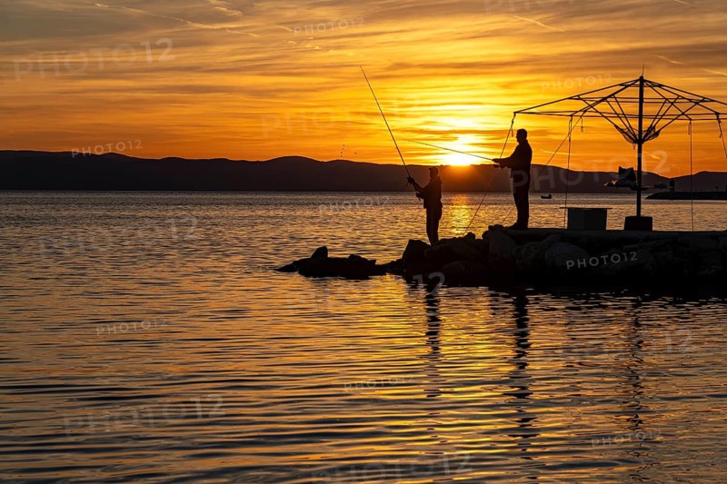 Anglers at sunset in Podgora, Croatia, Europe