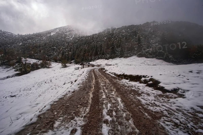 Snowy mountain landscape with cloudy sky and a narrow hiking trail to the Herzogstand, Kochel am See, Bavaria, Germany, Europe