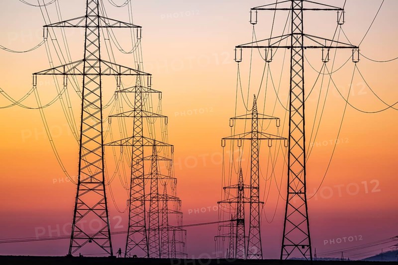 High-voltage pylons, overhead power lines at sunset. Schwieberdingen, Baden-Württemberg, Germany, Europe