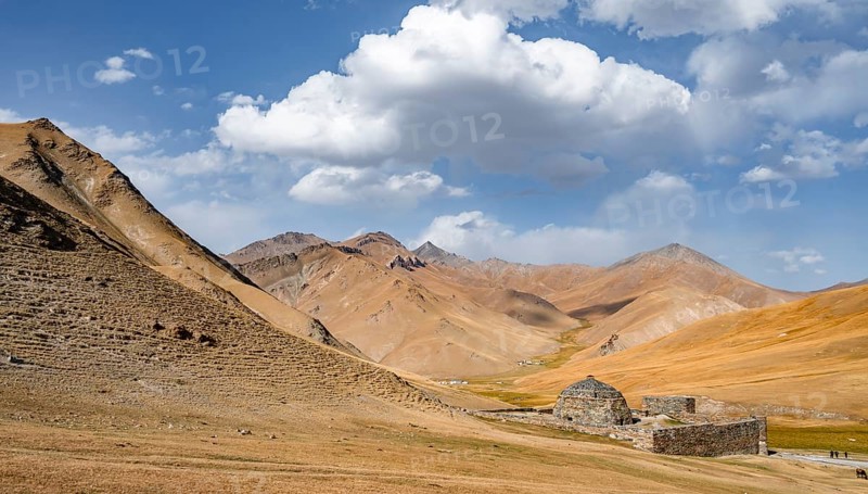 Historic caravanserai Tash Rabat from the 15th century, with yellow hills, Atbashy district in the Naryn region, Kyrgyzstan, Asia
