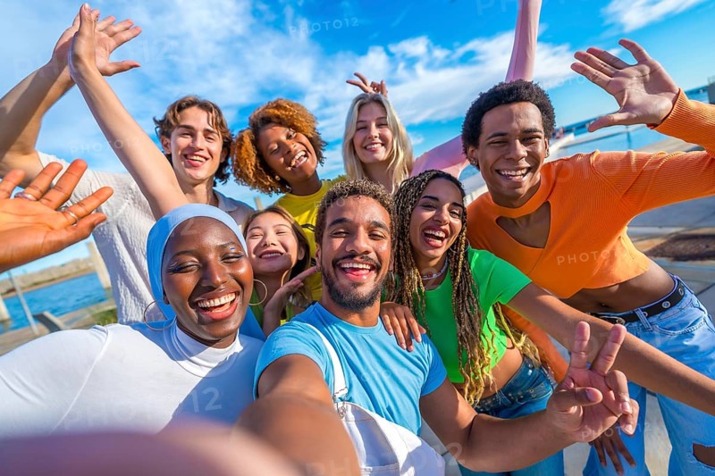 Large group of multi-ethnic happy young people taking a selfie in the city