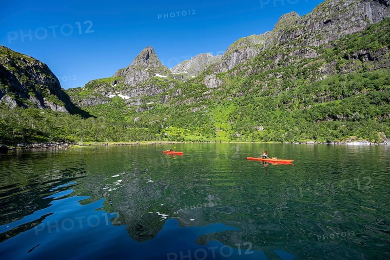 Two kayakers with red kayaks in the fjord Trollfjord, mountain peaks are reflected in the water, fjord landscape and mountains, Lofoten, Nordland, Norway, Europe