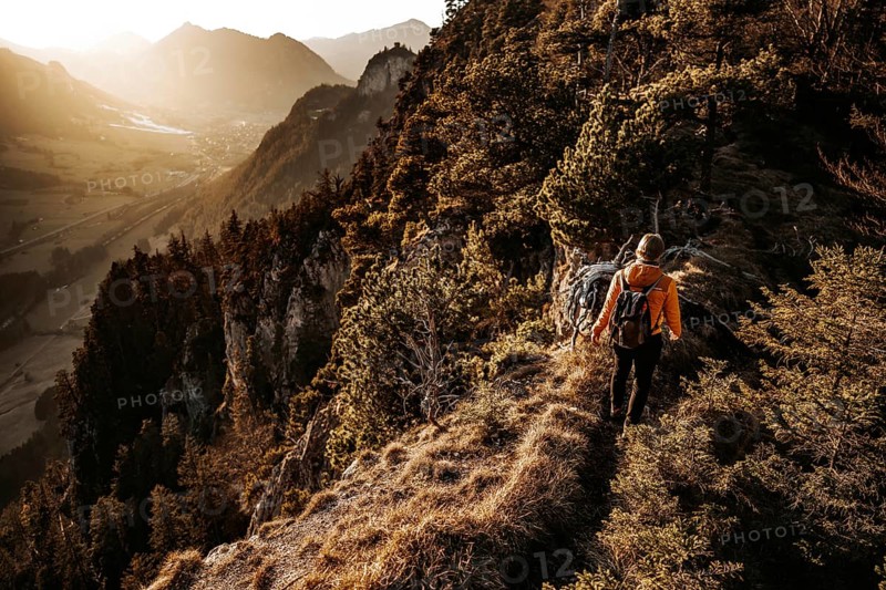 Hiker in the Allgäu at sunset in spring on the Zirmgrat near Pronten in the Allgäu
