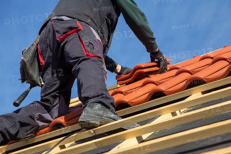 Roofer covering a tiled roof
