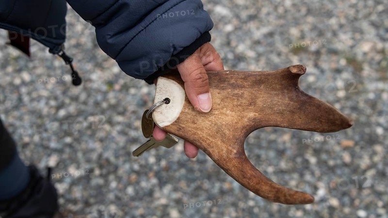 Part of a reindeer antler, hand holding key ring, Kongsvoll or Kongsvold Fjeldstue, historic mountain hut, Drivdalen valley, Dovrefjell, Oppdal municipality, Trøndelag county, Norway, Europe