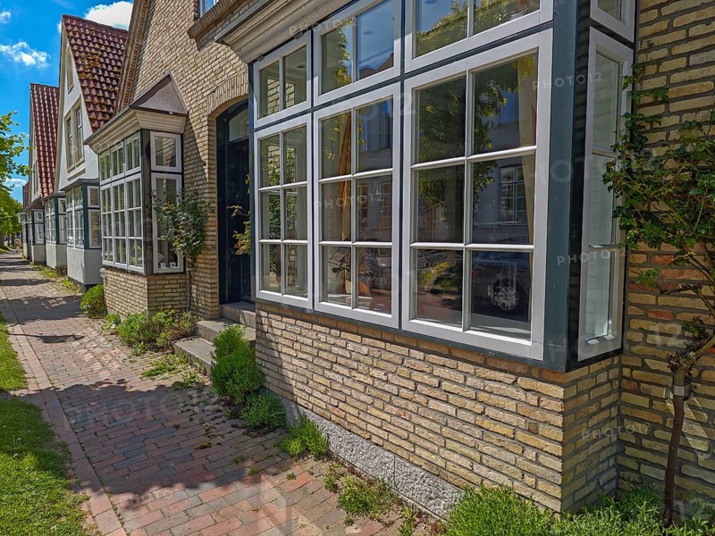 Historic row of houses with bay windows in Lange Strasse, gabled houses, footpath, trees, Arnis, building material yellow brick, smallest town in Germany, Schlei region, landscape Angeln, Schleswig-Holstein, Germany, Europe