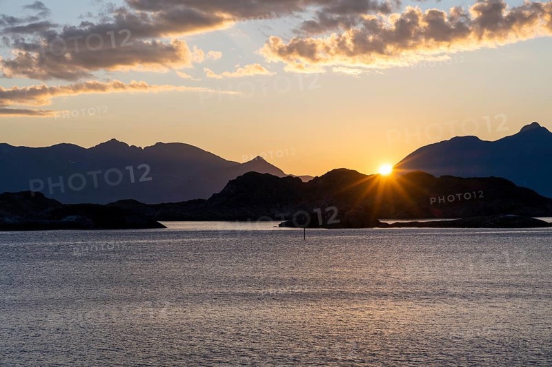 Sun setting behind Bergen, coastal landscape at sunset, Henningsvær, Lofoten, Nordland, Norway, Europe
