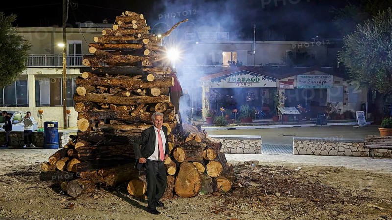 A man in a suit stands at night next to a smoking pile of wood, Mayor of Psinthos, Easter fire Psinthos, Holy Saturday, Easter, Psinthos, Rhodes, Dodecanese, Greek Islands, Greece, Europe