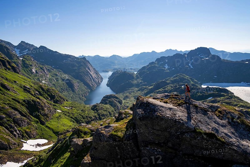 Mountaineer, young woman in front of mountain landscape, fjord Trollfjord and mountains, hike to Trollfjord Hytta, at Trollfjord and Raftsund, Lofoten, Nordland, Norway, Europe