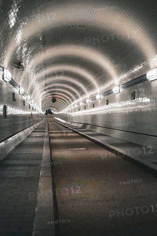 Long, illuminated tiled tunnel with symmetrical curves, old Elbe tunnel, Hamburg, Germany, Europe